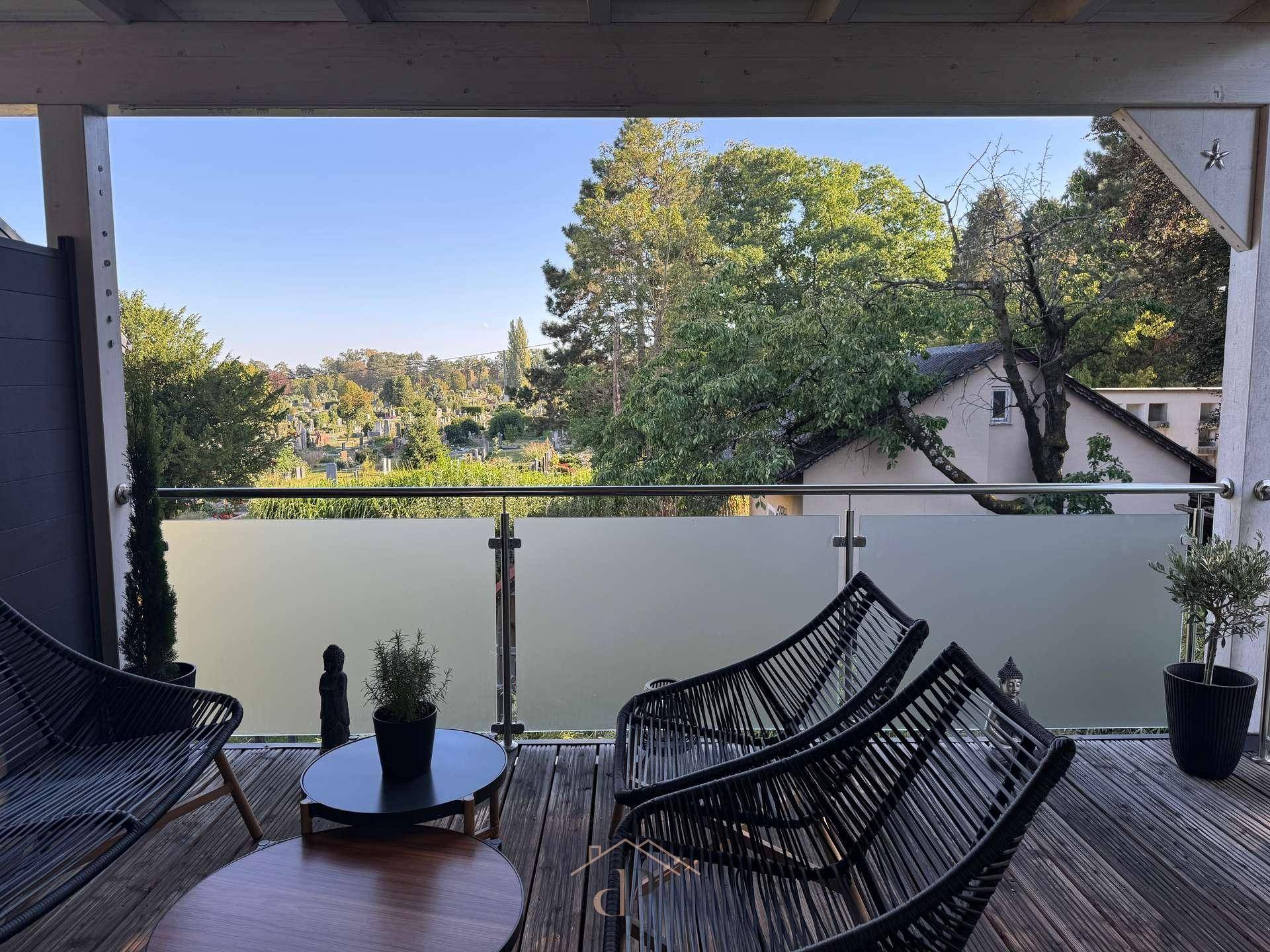 Großzügige überdachte Terrasse mit Holzbelag und weitem Blick auf die Umgebung.