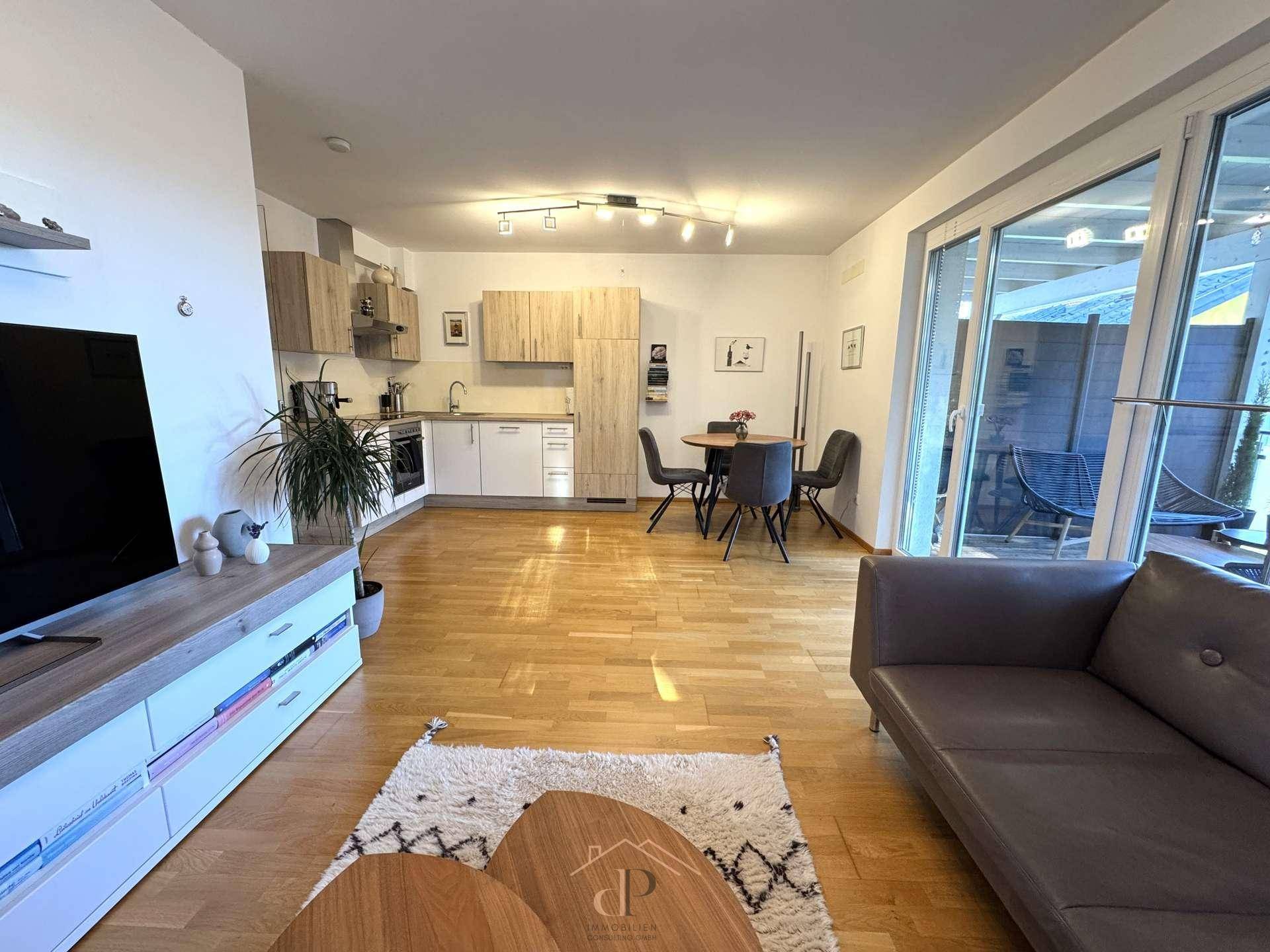 Heller offener Wohn- und Essbereich mit integrierter Küche und Zugang zur Terrasse.