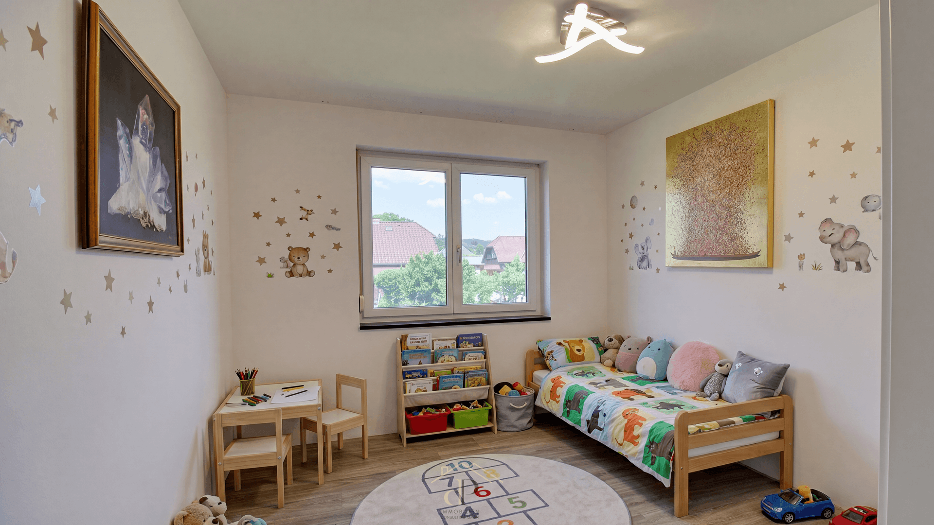 Freundliches Kinderzimmer mit Bett, Schreibtisch und spielerischer Wanddekoration, hell und einladend.