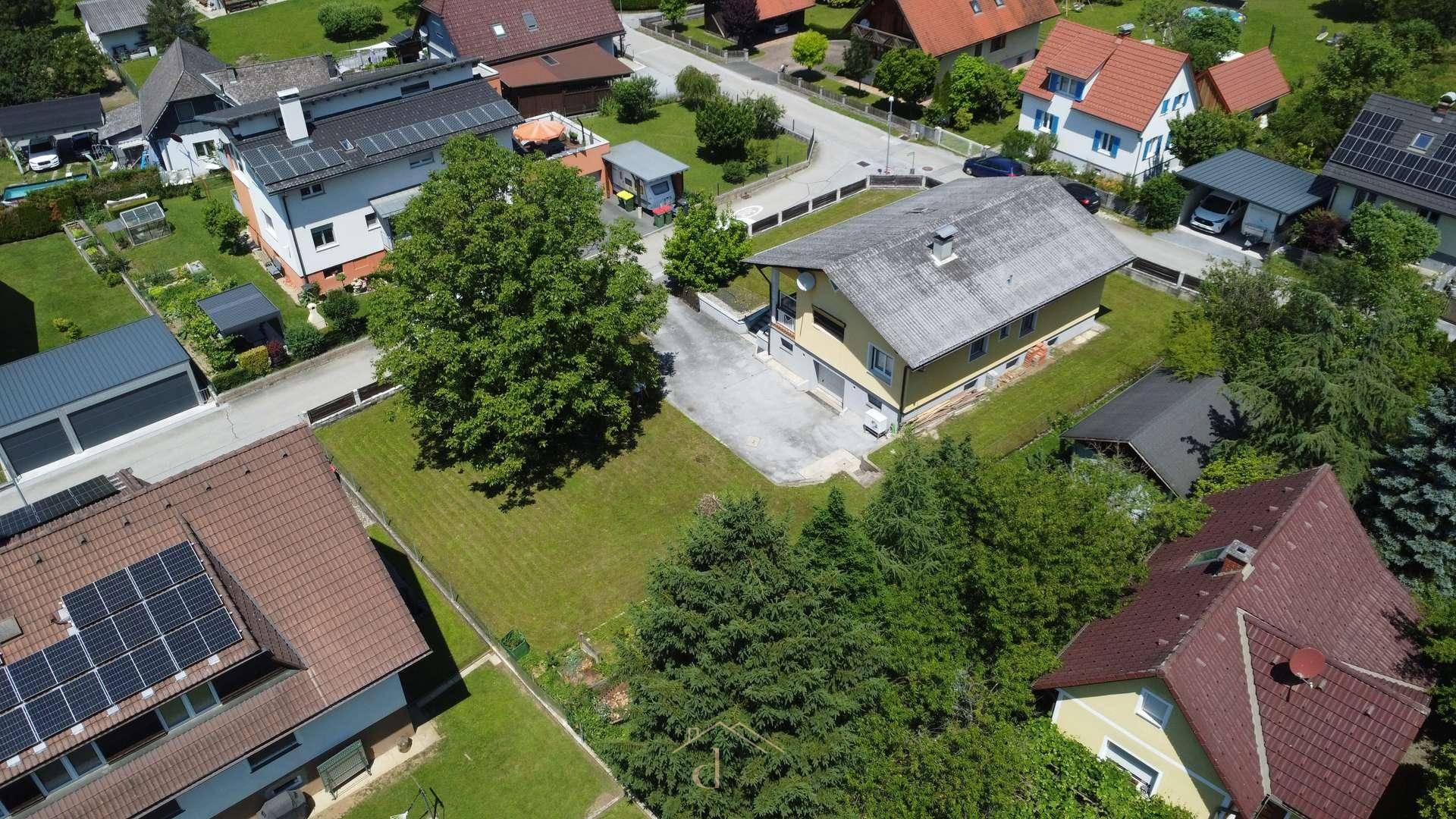 Weitläufige Luftaufnahme des Anwesens mit großem Garten, altem Baumbestand und umliegender Natur.