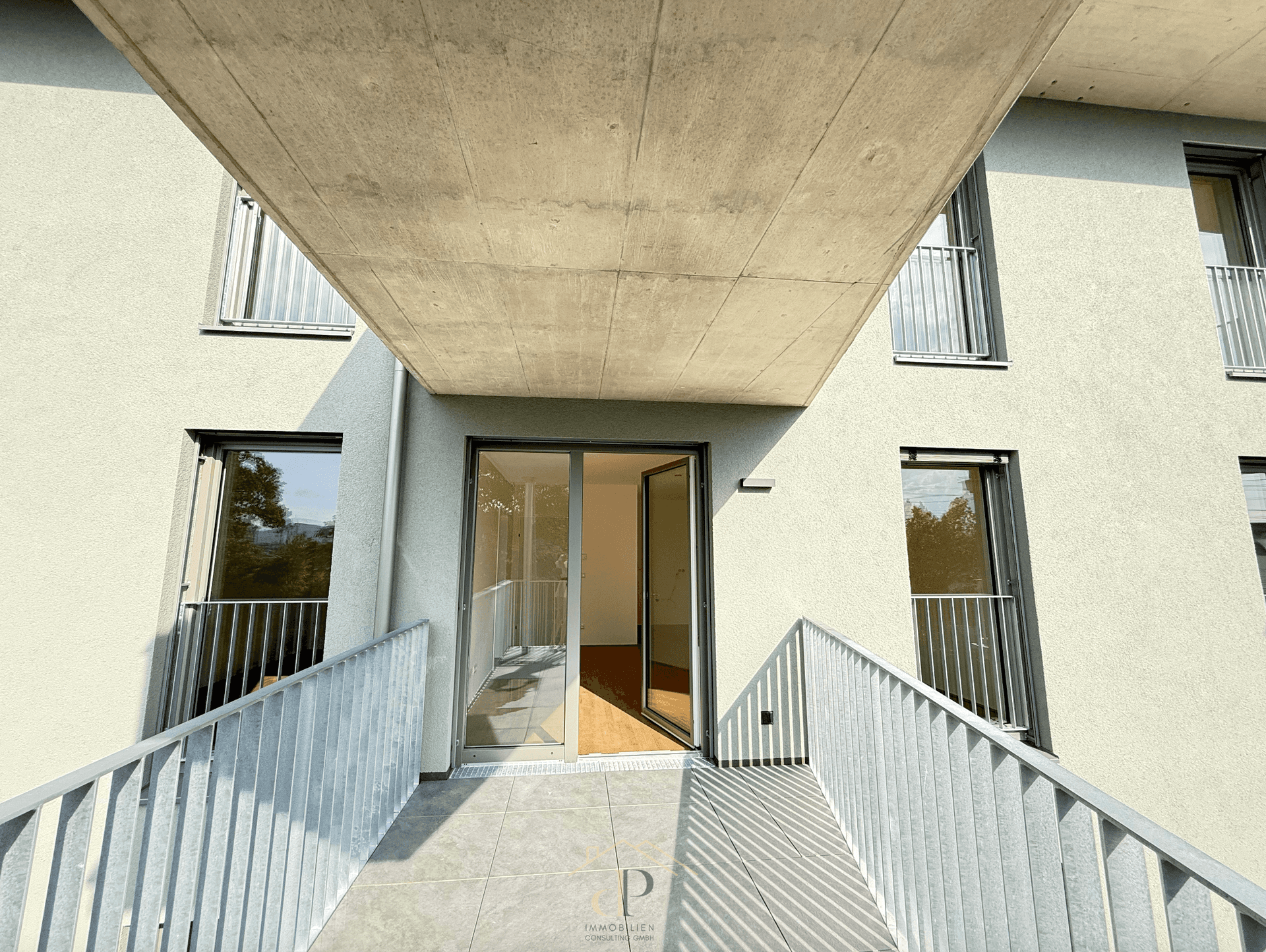 Moderner Balkon mit Fliesenboden und Blick in den hellen Innenraum.