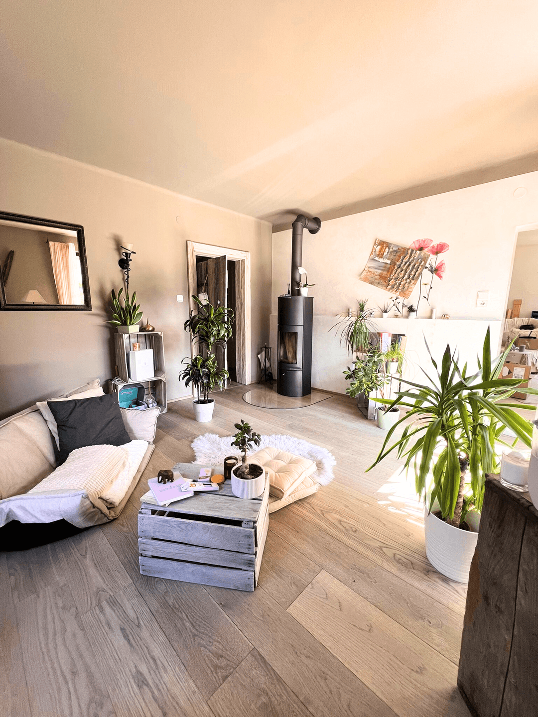 Gemütliches Wohnzimmer mit Holzboden, Sofa und einem modernen Holzofen.
