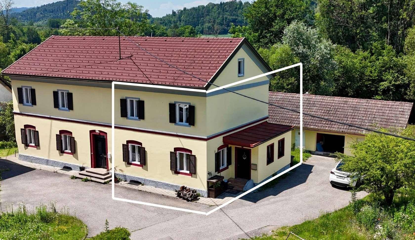 Ländliches Haus mit gelber Fassade und rotem Dach, umrandet zur Hervorhebung der Immobilie.