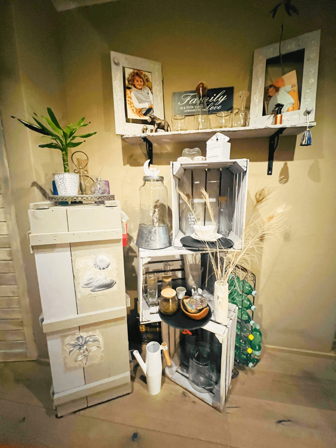 Dekorative Ecke mit Regalen aus Holzkisten, Pflanzen und persönlichen Erinnerungsstücken.