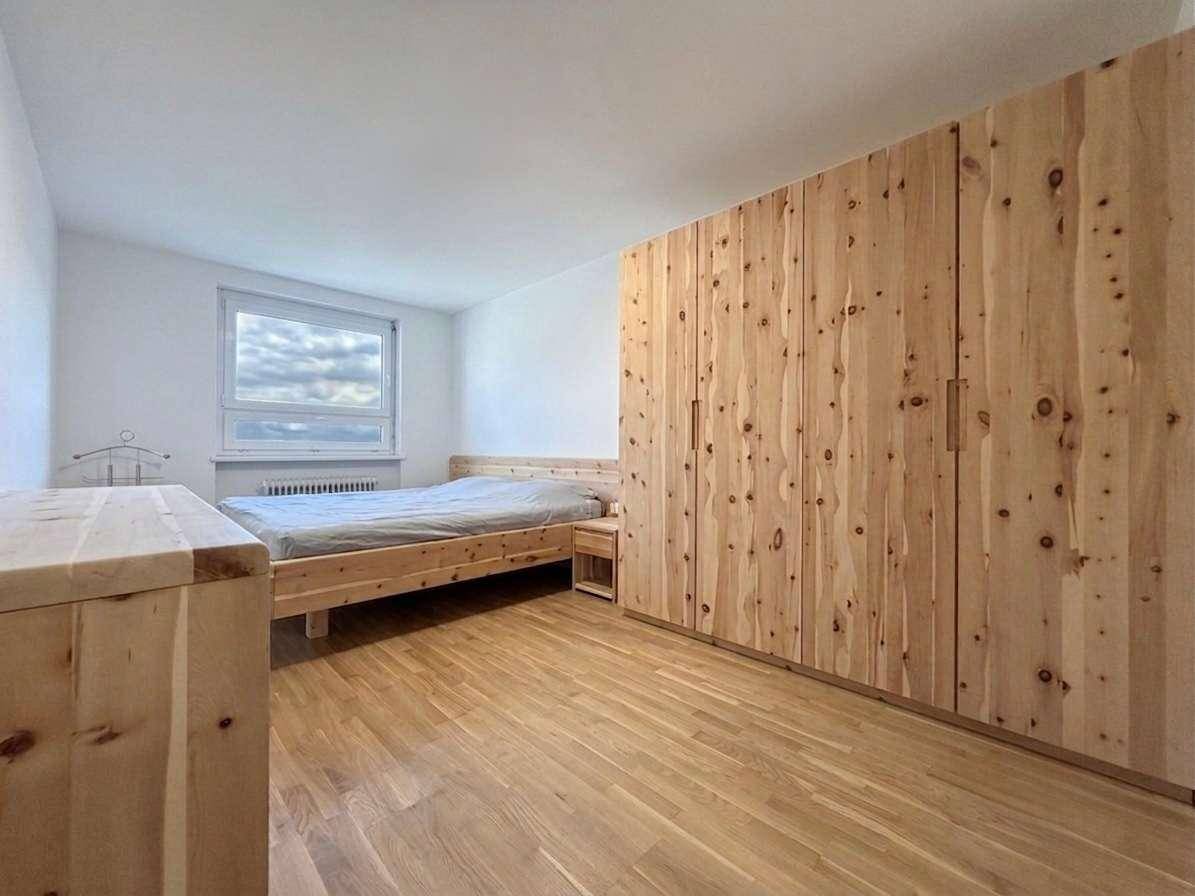 Geräumiges Schlafzimmer mit Holzboden und großen Holzschränken, bietet viel Stauraum.