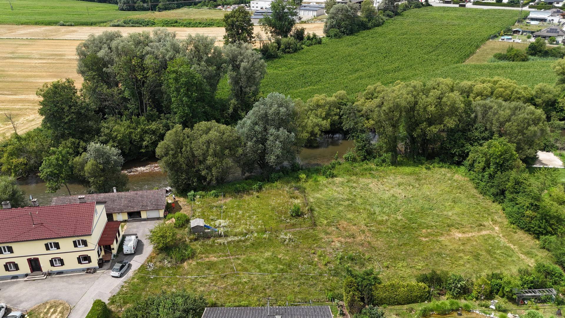 Überblick über ein Grundstück in ländlicher Lage, umgeben von Feldern, Bäumen und einem Fluss.