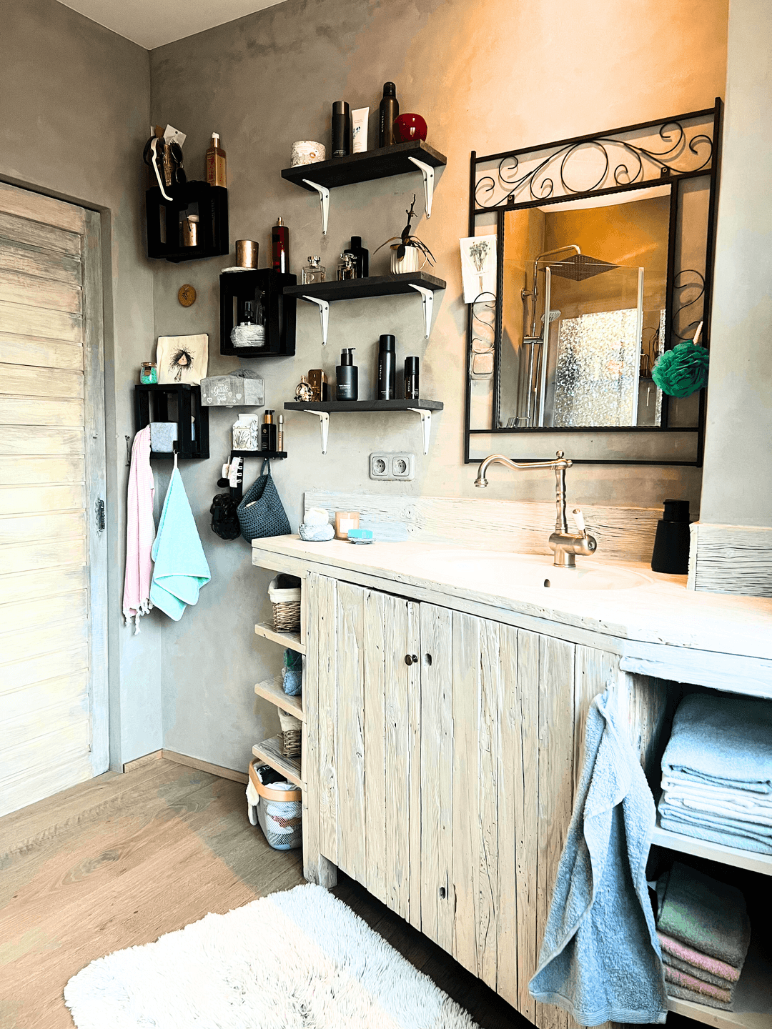 Badezimmer mit rustikalem Holzwaschtisch, Einzelwaschbecken und dekorativen Regalen.