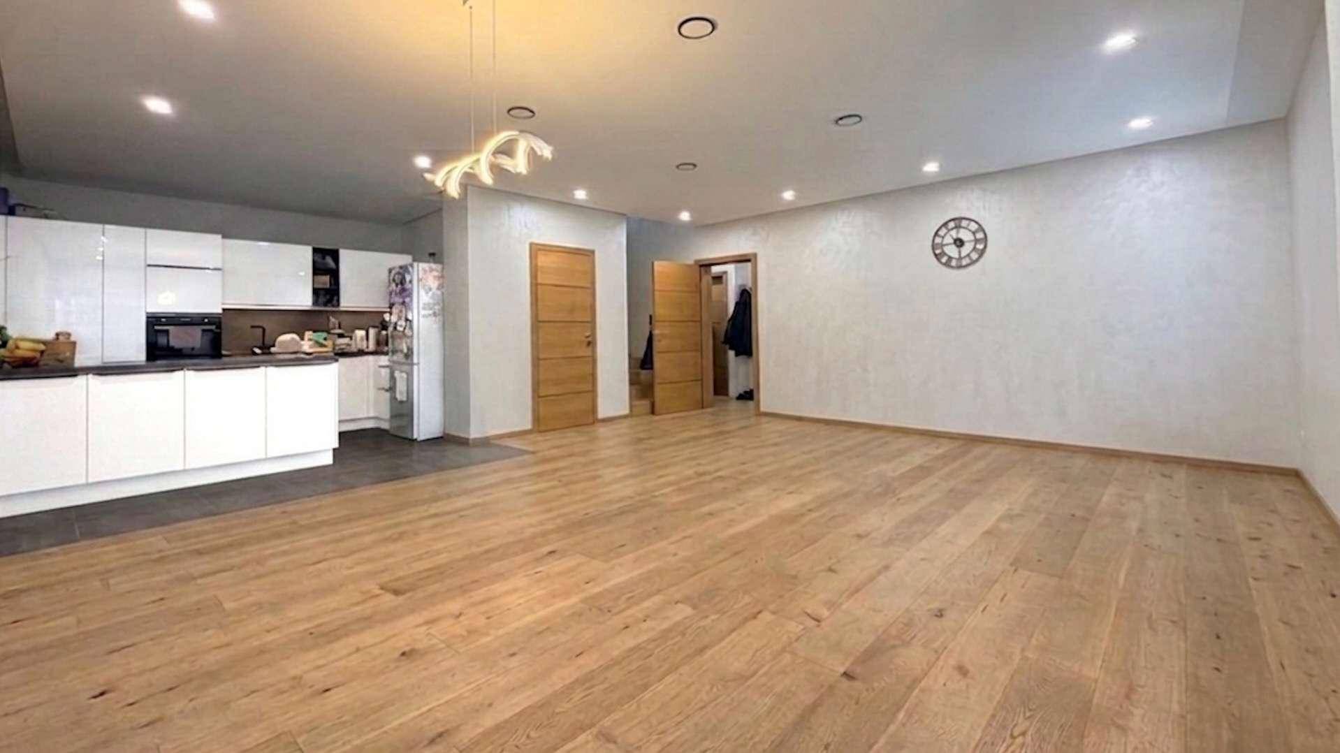 Offener Wohn- und Essbereich mit Holzboden, integrierter Küche und viel Platz.
