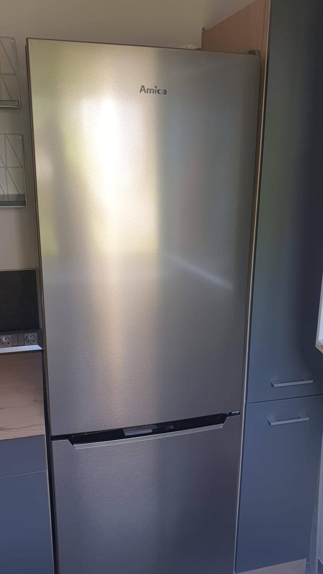 Moderner Edelstahlkühlschrank der Marke Amica, integriert in die Küchenzeile.