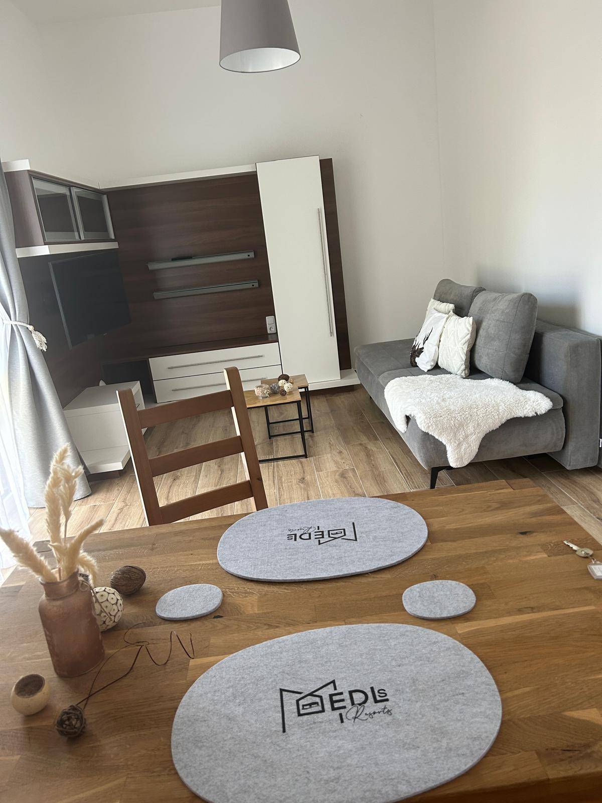 Gemütlicher Wohn-Essbereich mit Holzboden, modernem Sofa und Esstisch für gesellige Stunden.