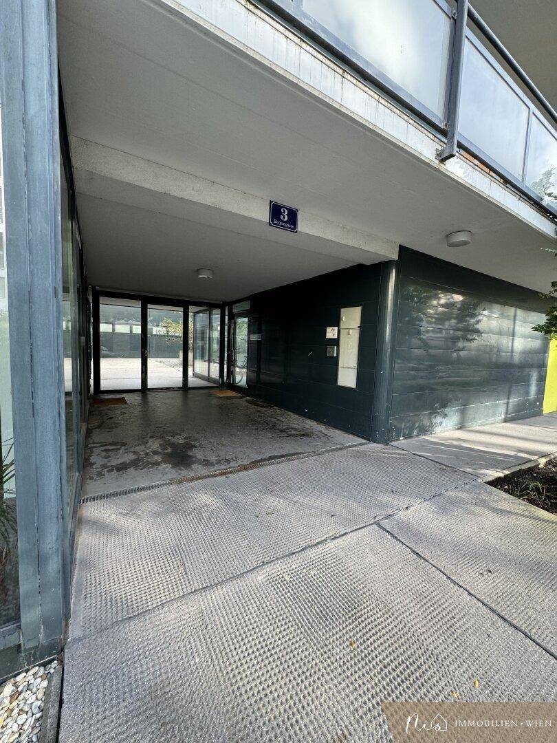 Eingangsbereich eines modernen Gebäudes mit Glasfront und Nummer 3.