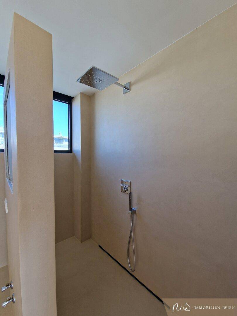 Geräumiger Duschbereich mit Regendusche und modernen Armaturen im Badezimmer.