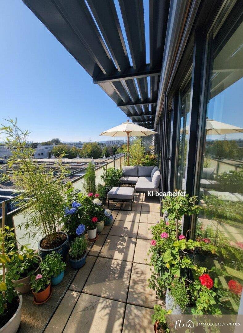 Möblierter Balkon mit Pflanzen, Sonnenschirm und Sitzgelegenheiten, ideal zum Entspannen.