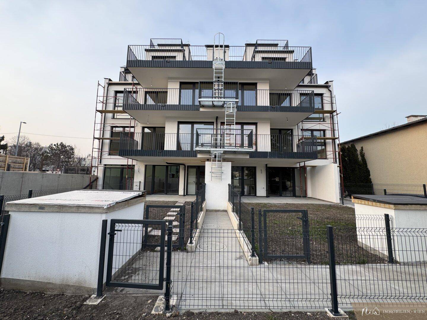 Moderne Wohnanlage im Neubau mit mehreren Balkonen und Außentreppe.