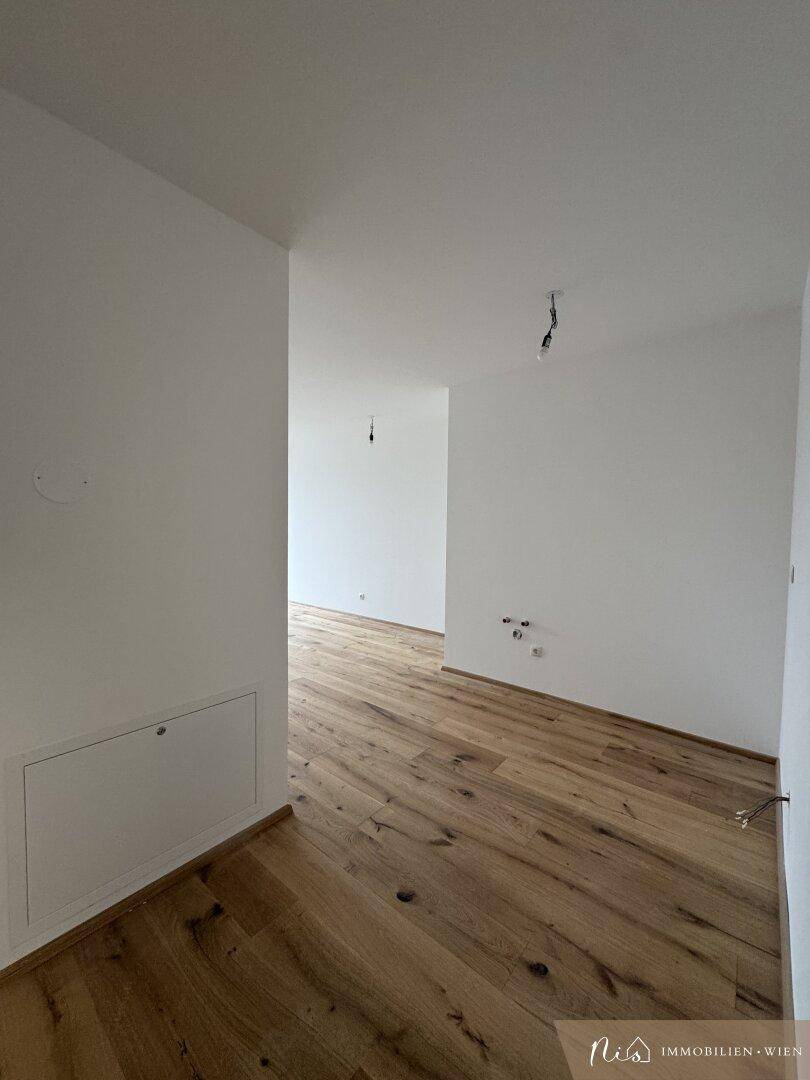 Heller Flur mit Holzboden und Zugang zu verschiedenen Räumen.