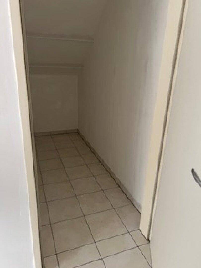 Praktischer Abstellraum im Dachgeschoss mit Fliesenboden und weiß gestrichenen Wänden.