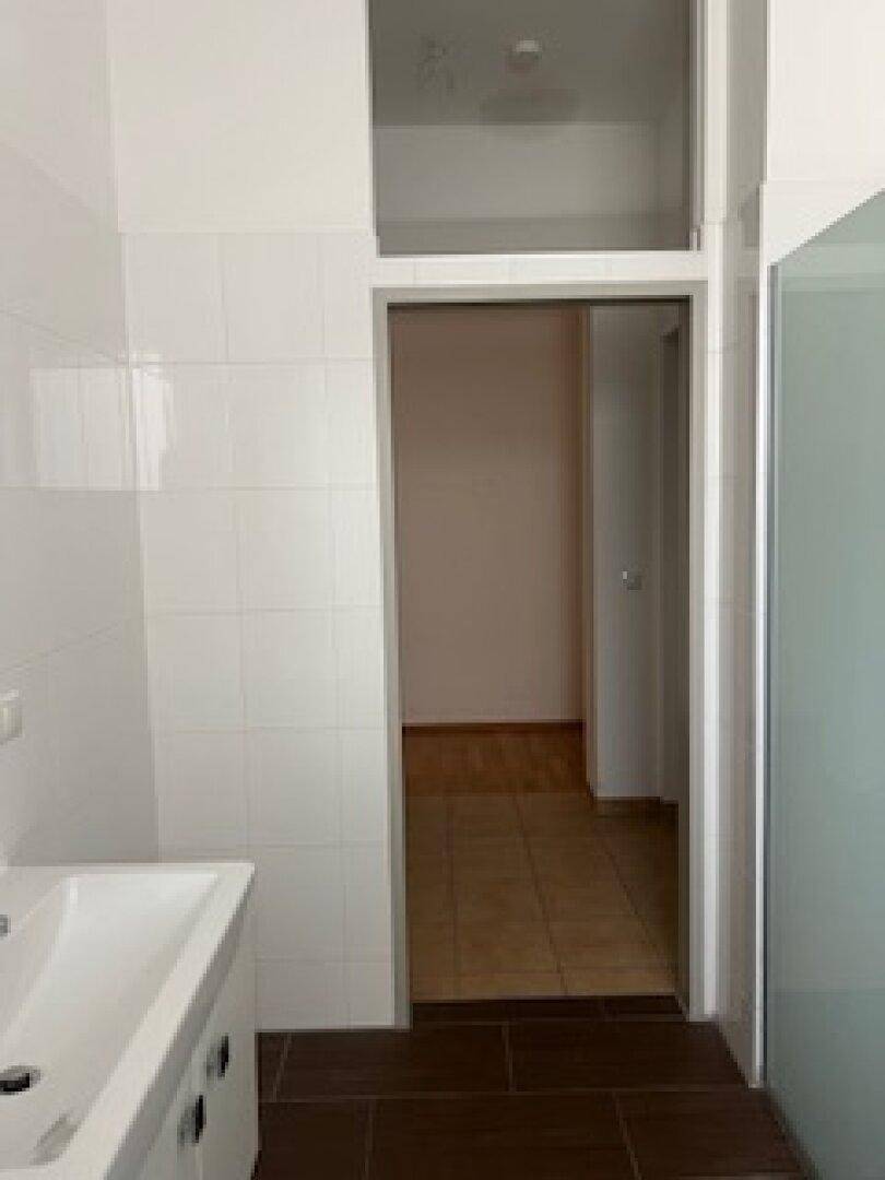 Badezimmer mit Waschbecken und Zugang zu einem angrenzenden Raum.