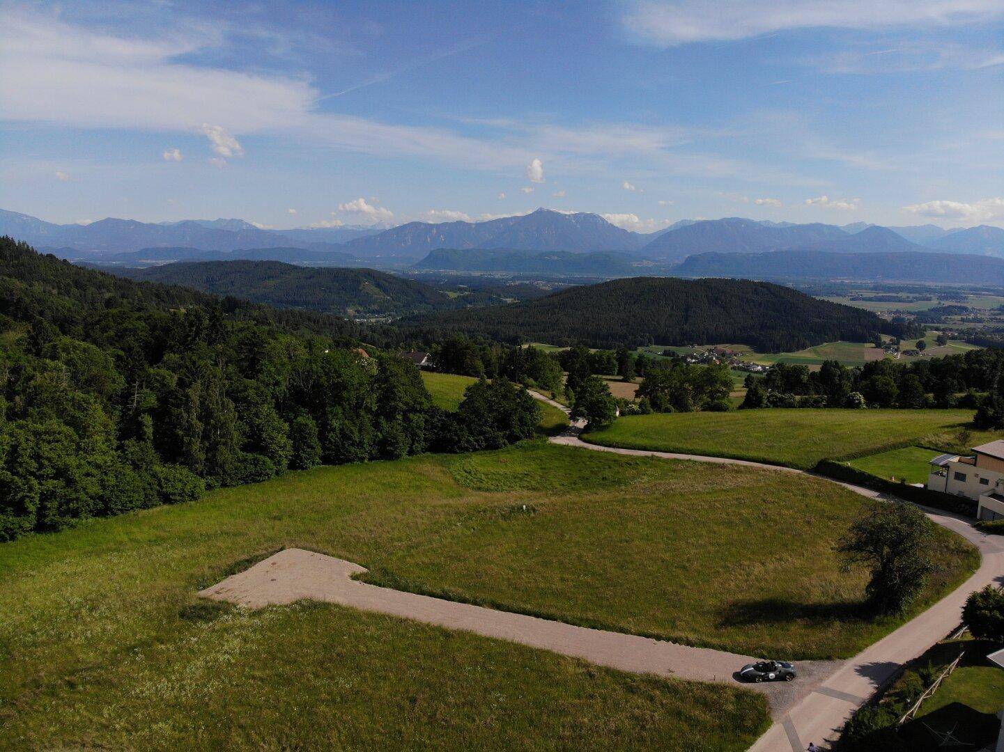 Großes Grundstück mit Zufahrtsweg und malerischem Ausblick auf die weite Bergwelt und Natur.