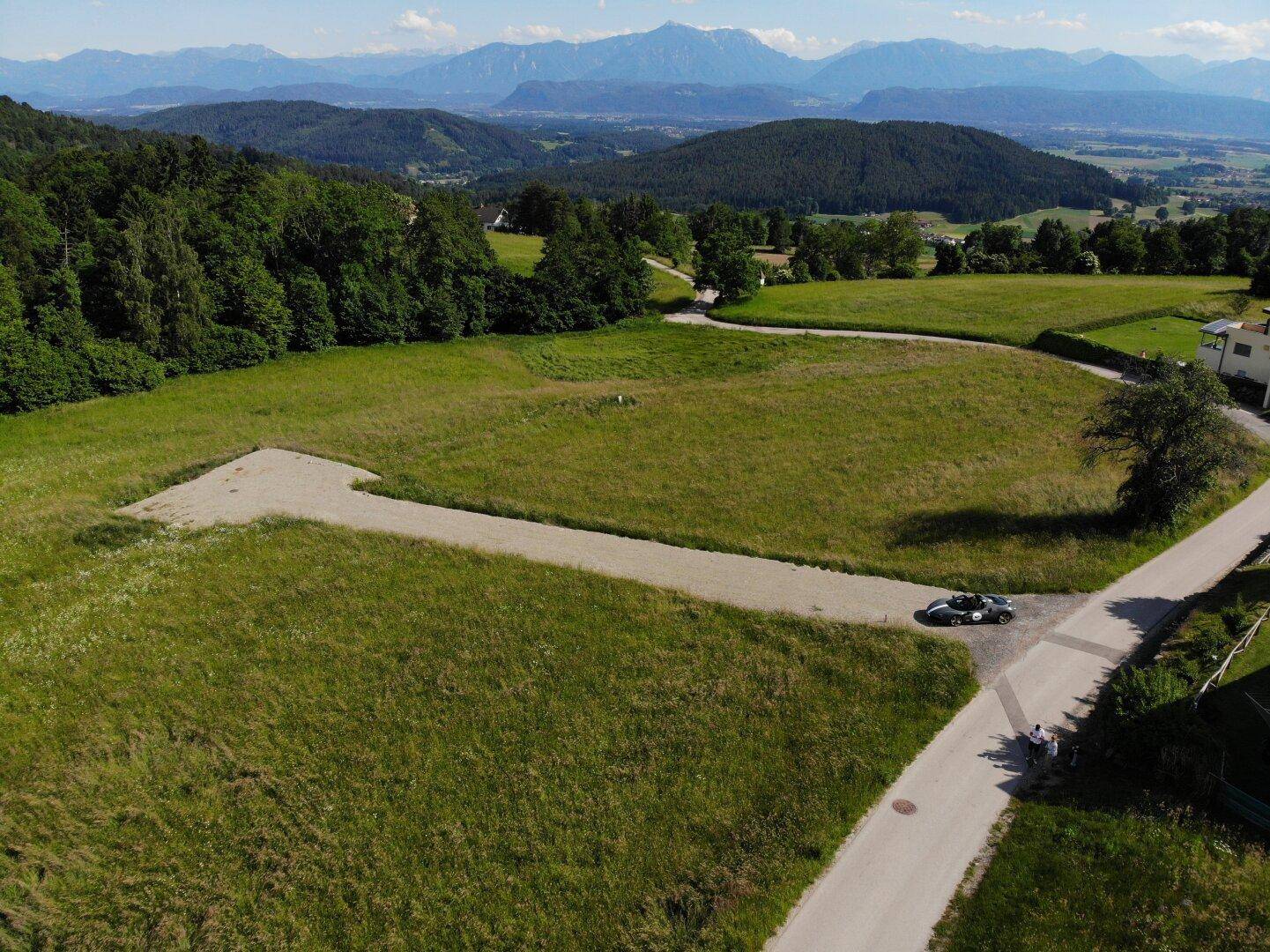 Grundstück mit Zufahrtsweg und weitem Blick auf die umliegende Natur und die fernen Berge.