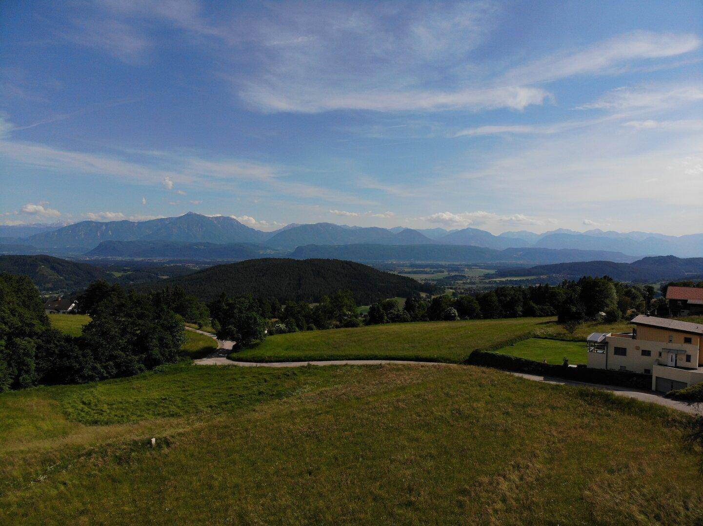 Weitläufiges Grundstück mit Blick auf die grüne Umgebung und die majestätischen Berge in der Ferne.