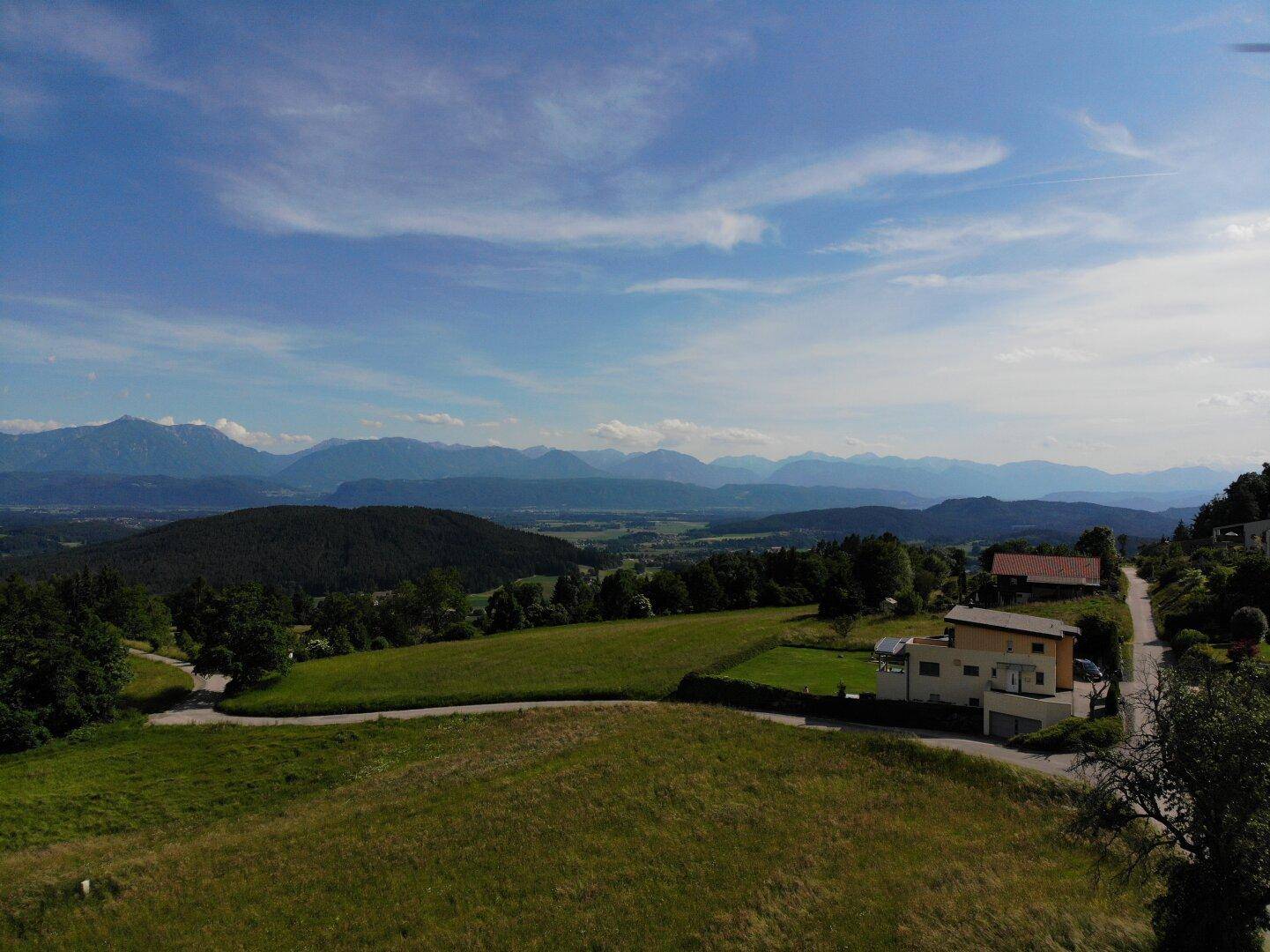 Weitläufiges Grundstück mit Blick auf die grüne Umgebung und die majestätischen Berge in der Ferne.
