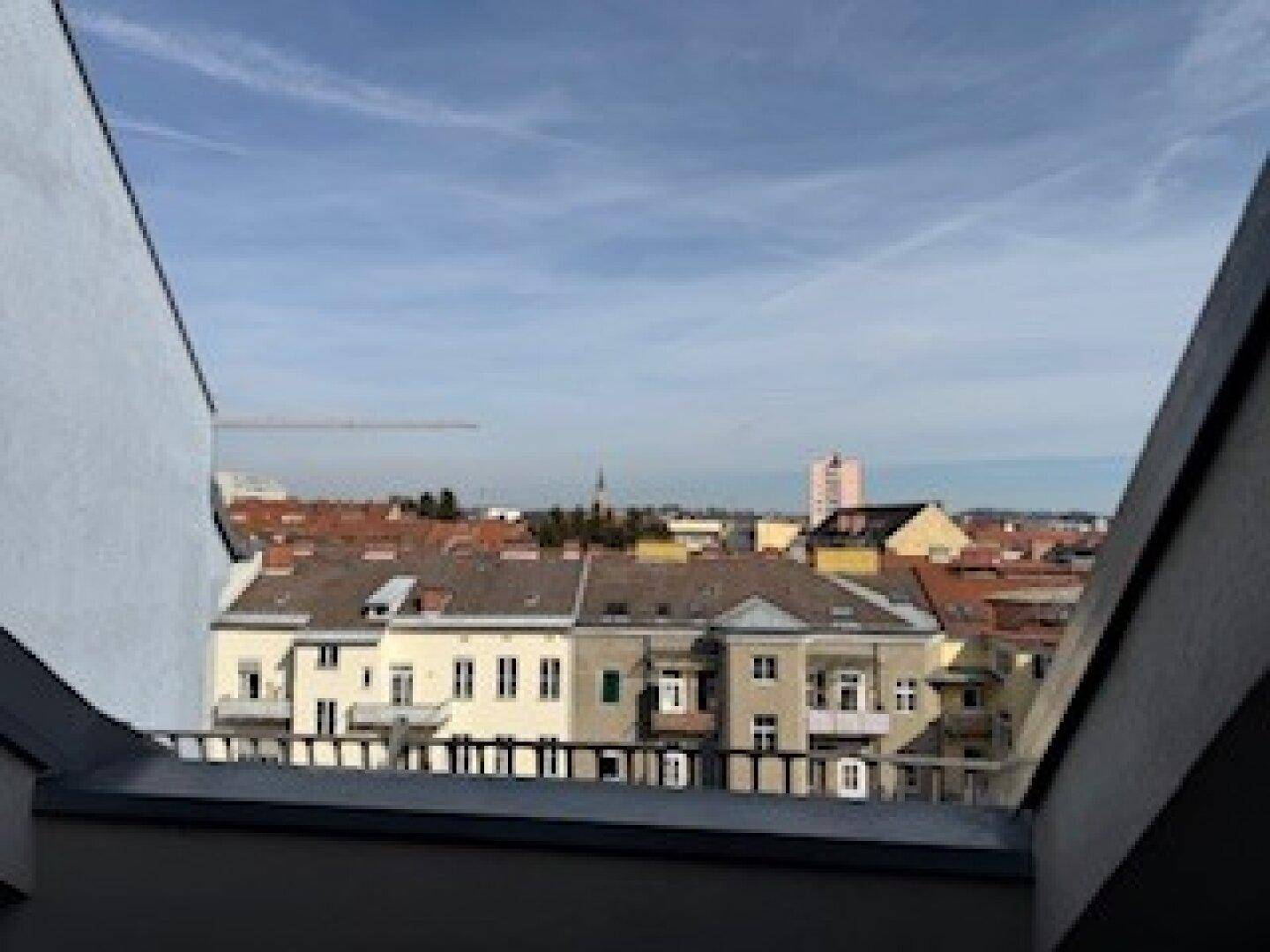 Panoramablick über die Dächer der Stadt unter einem klaren blauen Himmel.