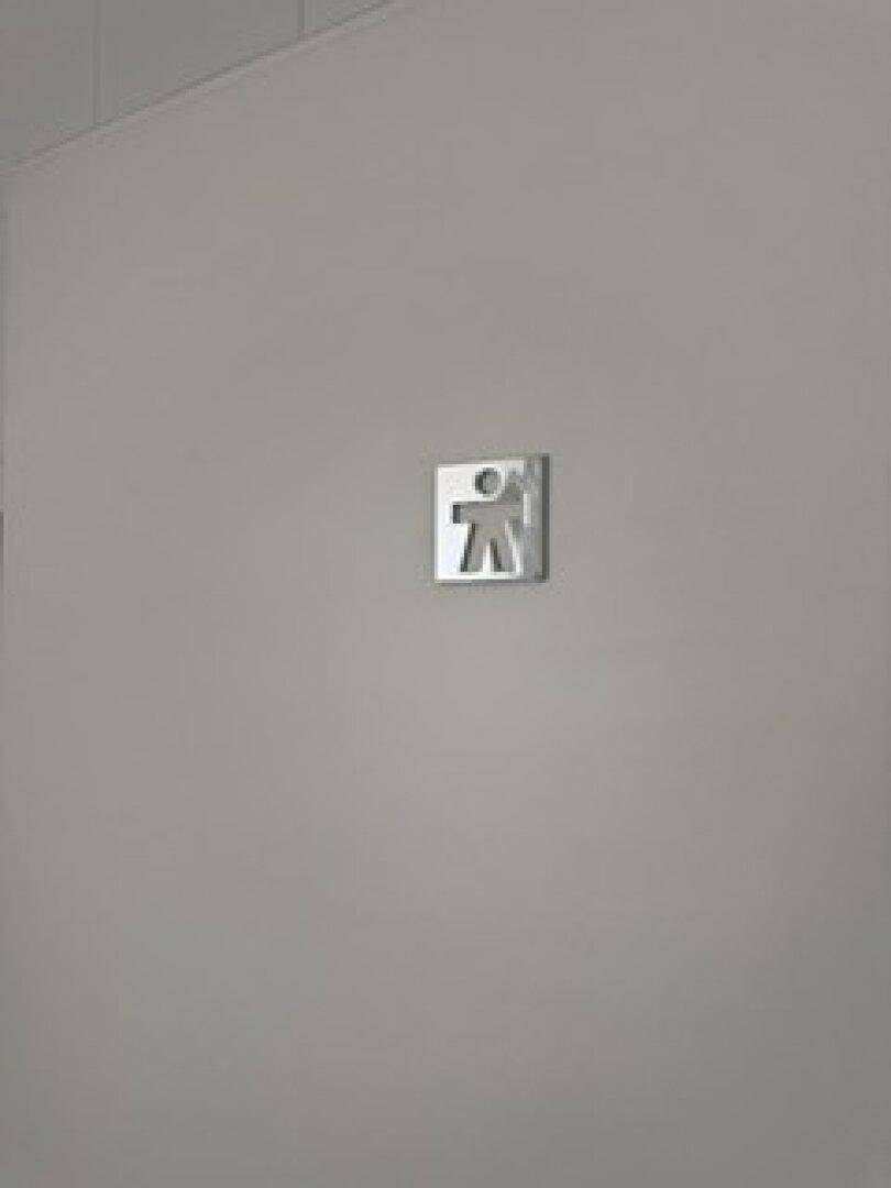 Wand mit einem Piktogramm für eine Herrentoilette in einem schlichten und funktionalen Design.