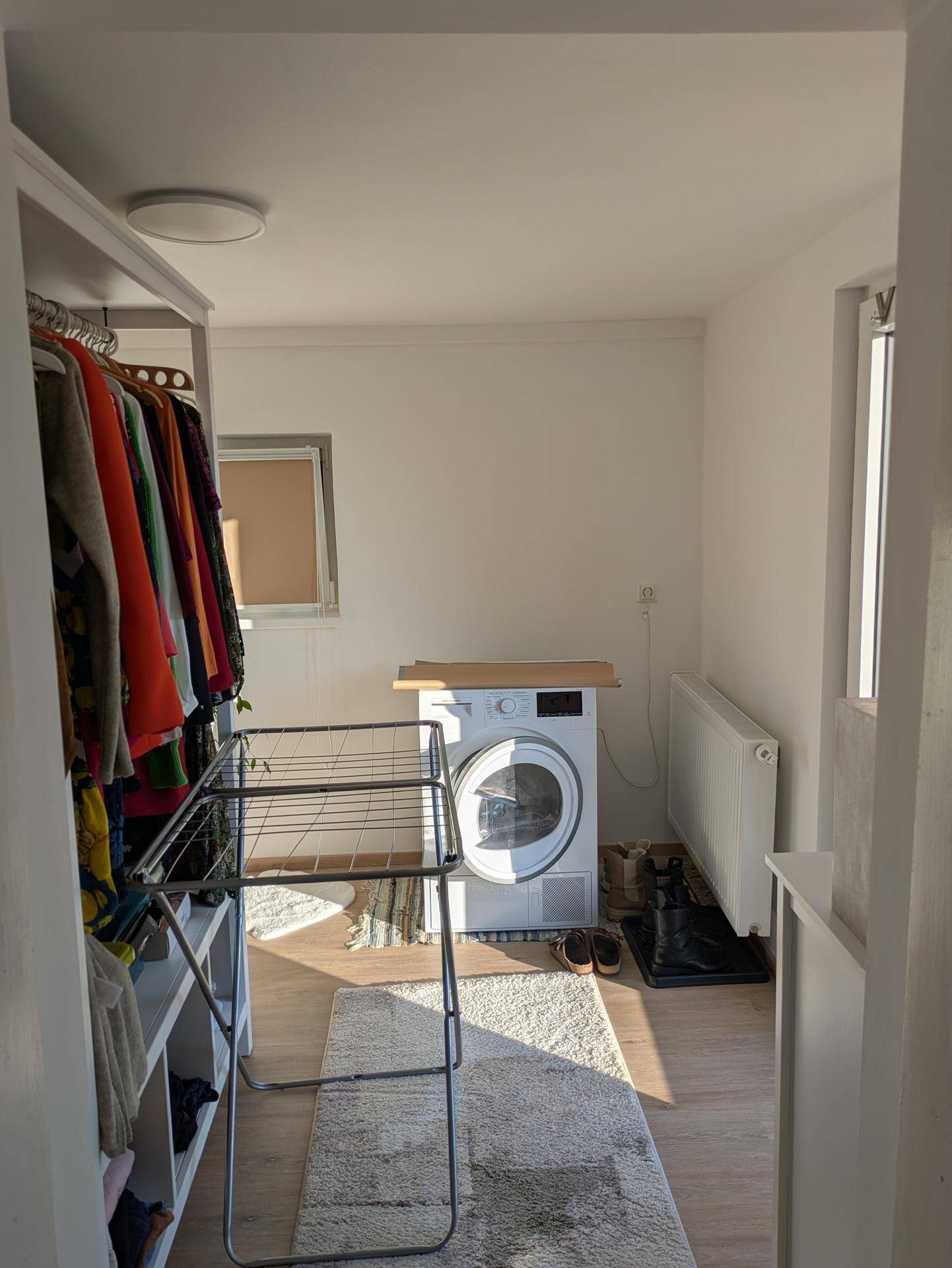 Praktischer Hauswirtschaftsraum mit Waschmaschine, Trockner und Wäscheständer.