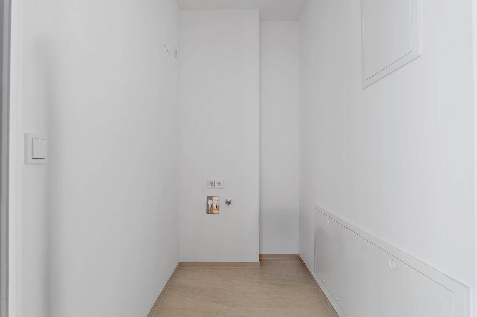 Praktischer Hauswirtschaftsraum mit Anschlüssen für Waschmaschine und Trockner.