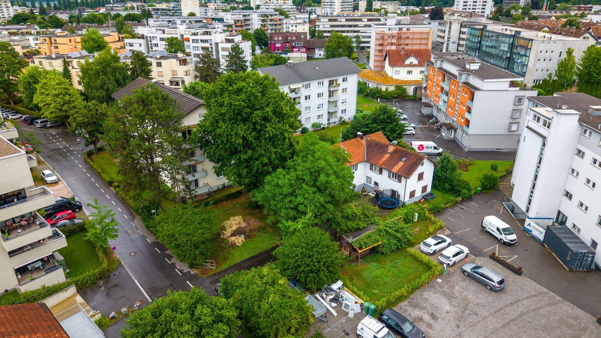 Weitläufige Luftaufnahme einer Wohnsiedlung mit Einfamilienhäusern und Mehrfamilienhäusern in städtischer Umgebung.