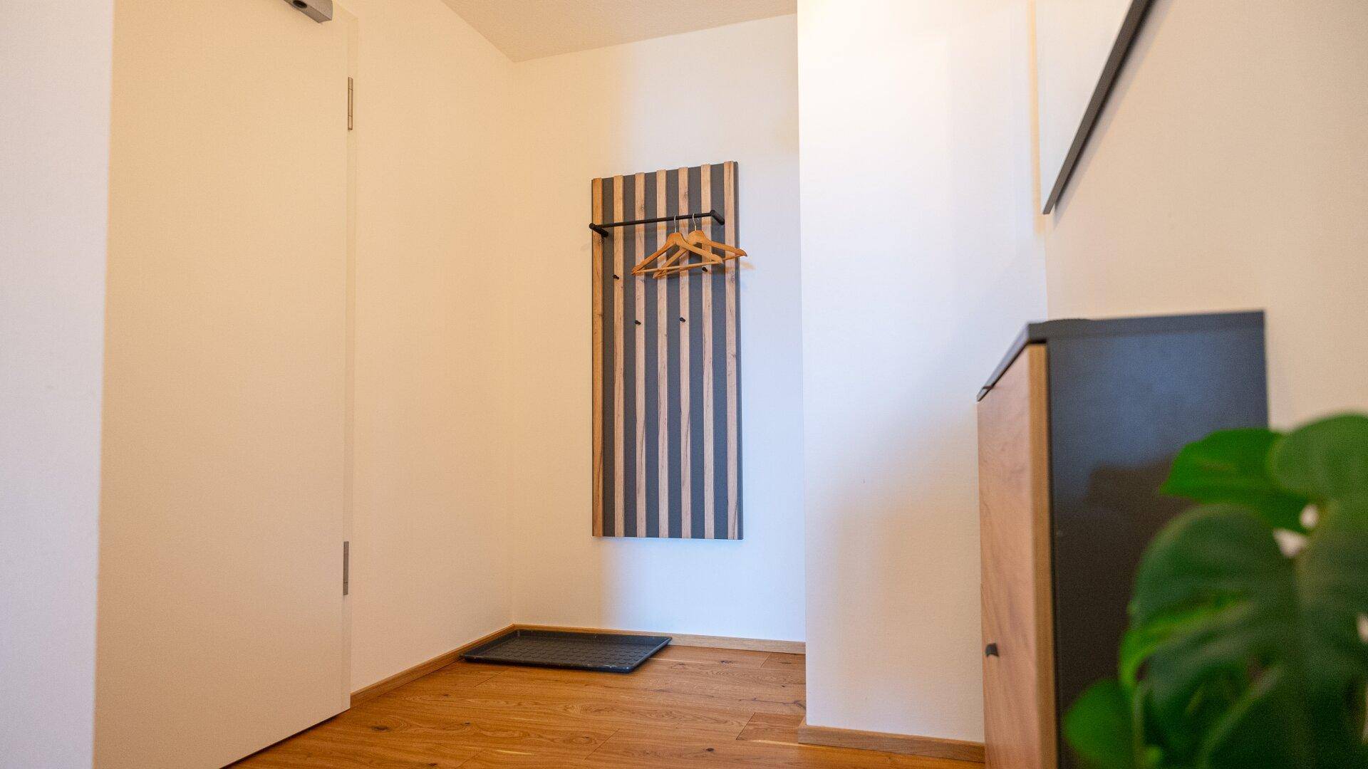 Eingangsbereich mit Garderobe und Holzboden, hell und einladend.