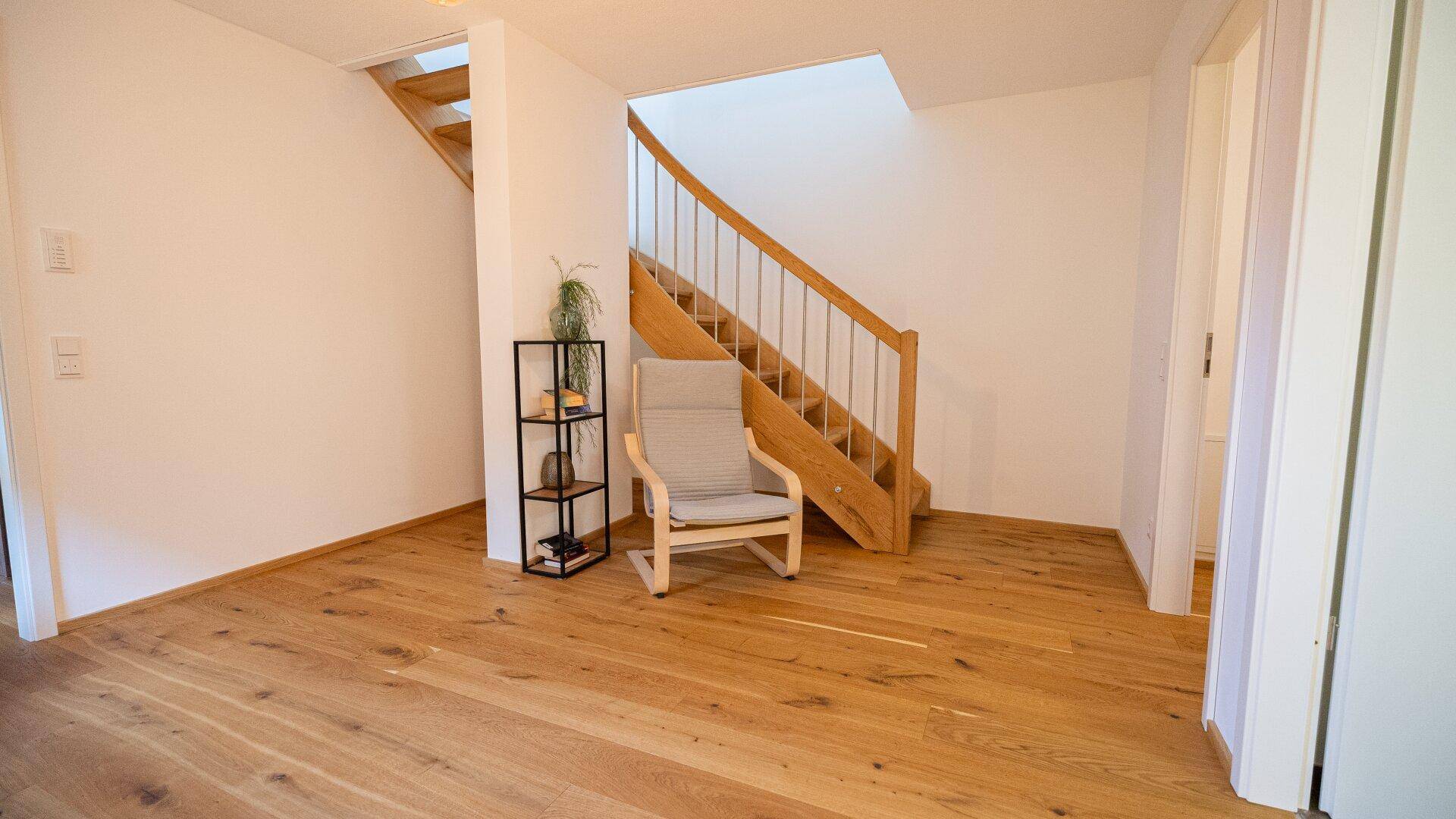 Heller Flur mit Holztreppe und Holzboden, führt zu den oberen Etagen.