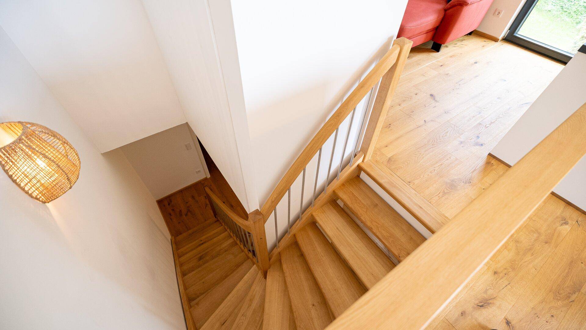 Holztreppe mit Geländer, die die verschiedenen Ebenen des Hauses verbindet.
