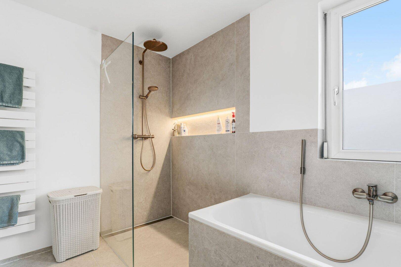Helles Badezimmer mit begehbarer Dusche, Badewanne und Fenster.