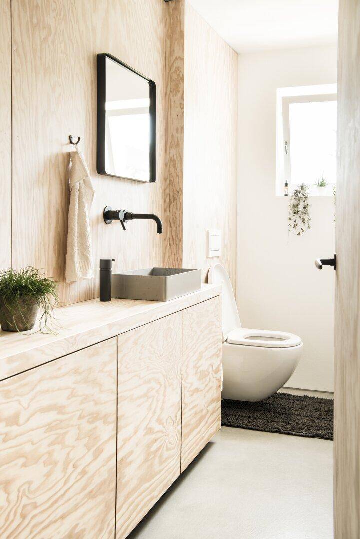Modernes Gäste-WC mit Holzwaschtisch, Aufsatzwaschbecken und wandhängender Toilette.