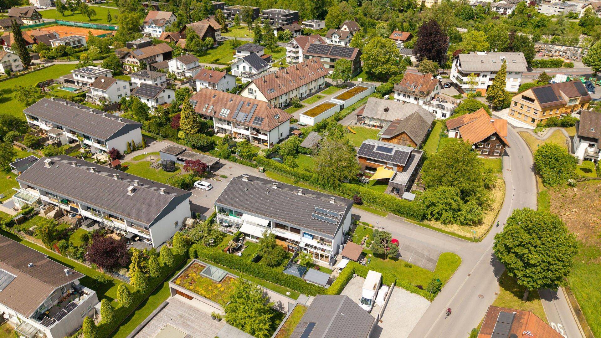 Luftaufnahme einer grünen Wohnsiedlung mit Einfamilienhäusern und Reihenhäusern in ländlicher Umgebung.