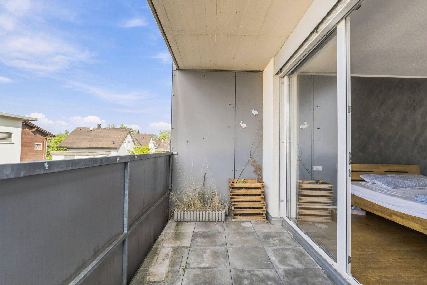 Geräumiger Balkon mit Fliesenboden und Blick auf die Nachbarschaft.