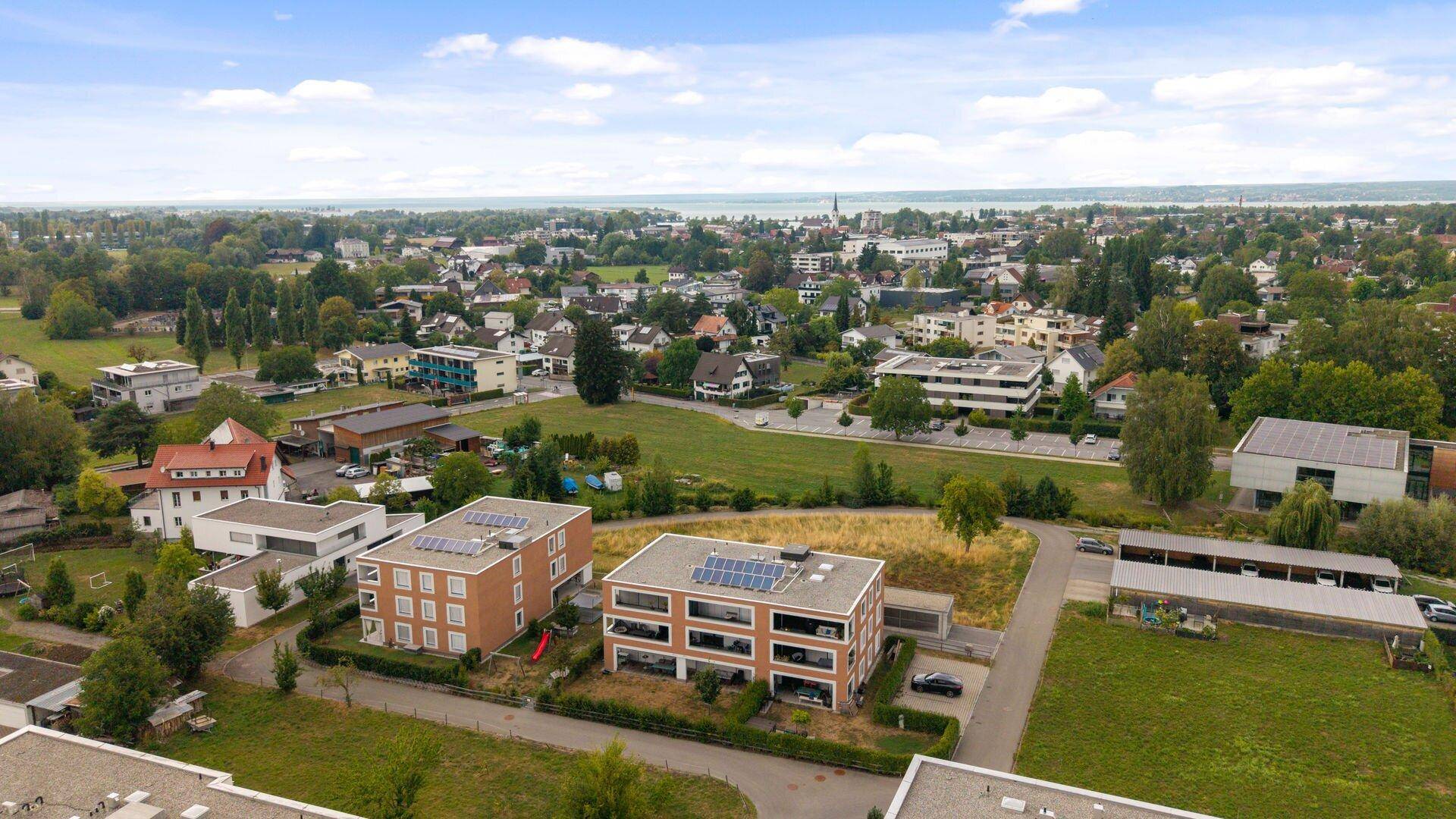 Weitläufige Luftaufnahme der Wohnsiedlung mit Blick auf den See und die umliegende Landschaft.
