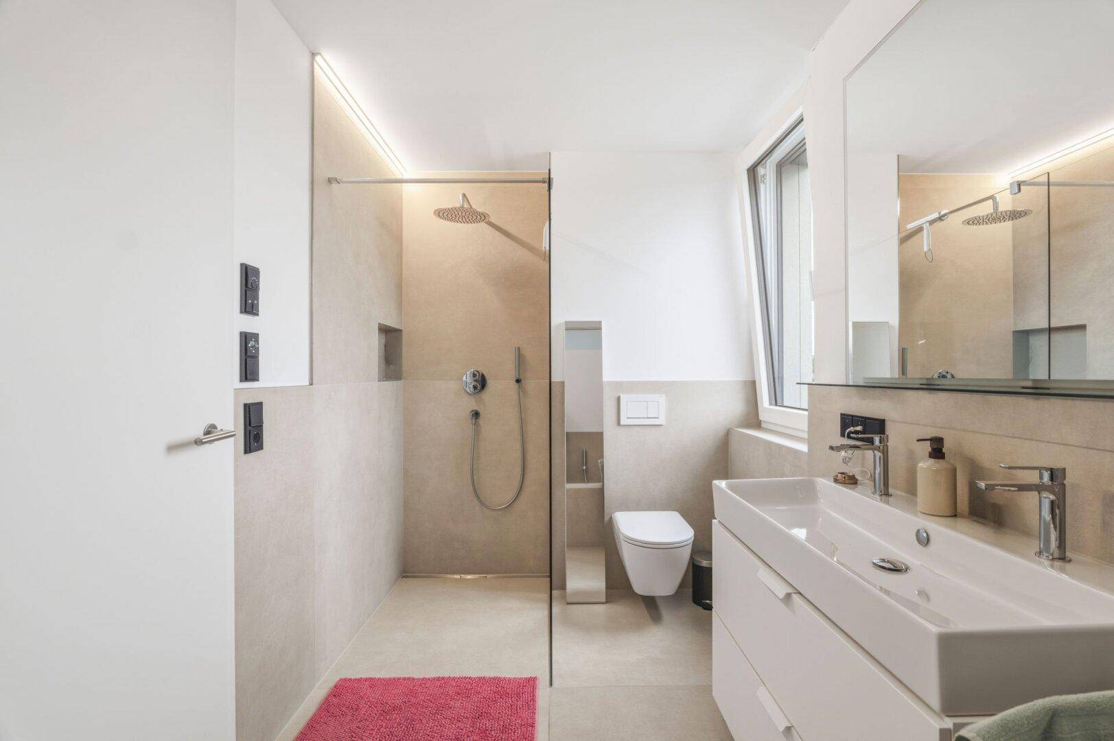 Zeitgemäßes Badezimmer mit begehbarer Dusche, Waschtisch und Fenster.