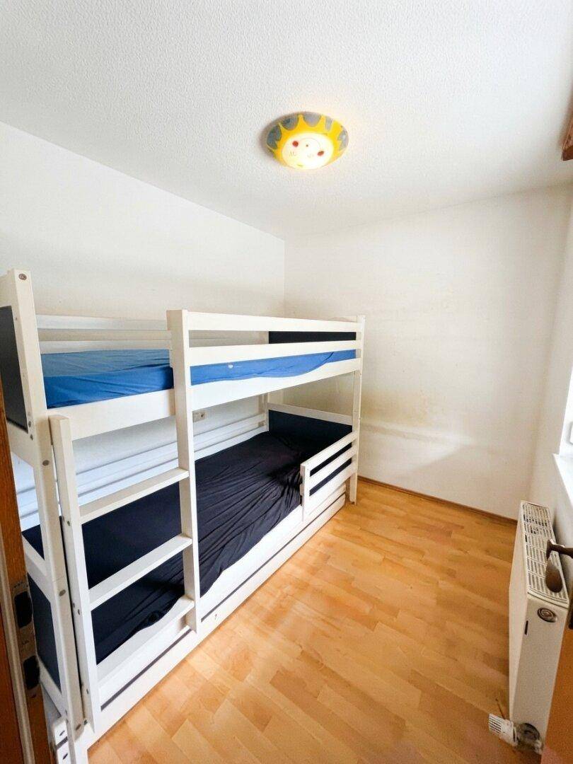 Kinderzimmer mit Etagenbett und Laminatboden, ideal für Geschwister oder Gäste.