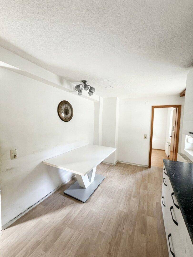 Essbereich in der Küche mit einem modernen Tisch und Blick auf den angrenzenden Raum.
