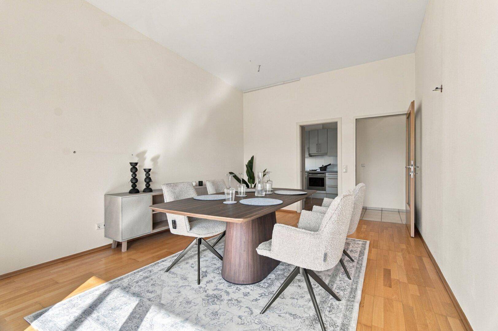 Geräumiger Essbereich mit Holzboden, modernem Sideboard und Zugang zur Küche.