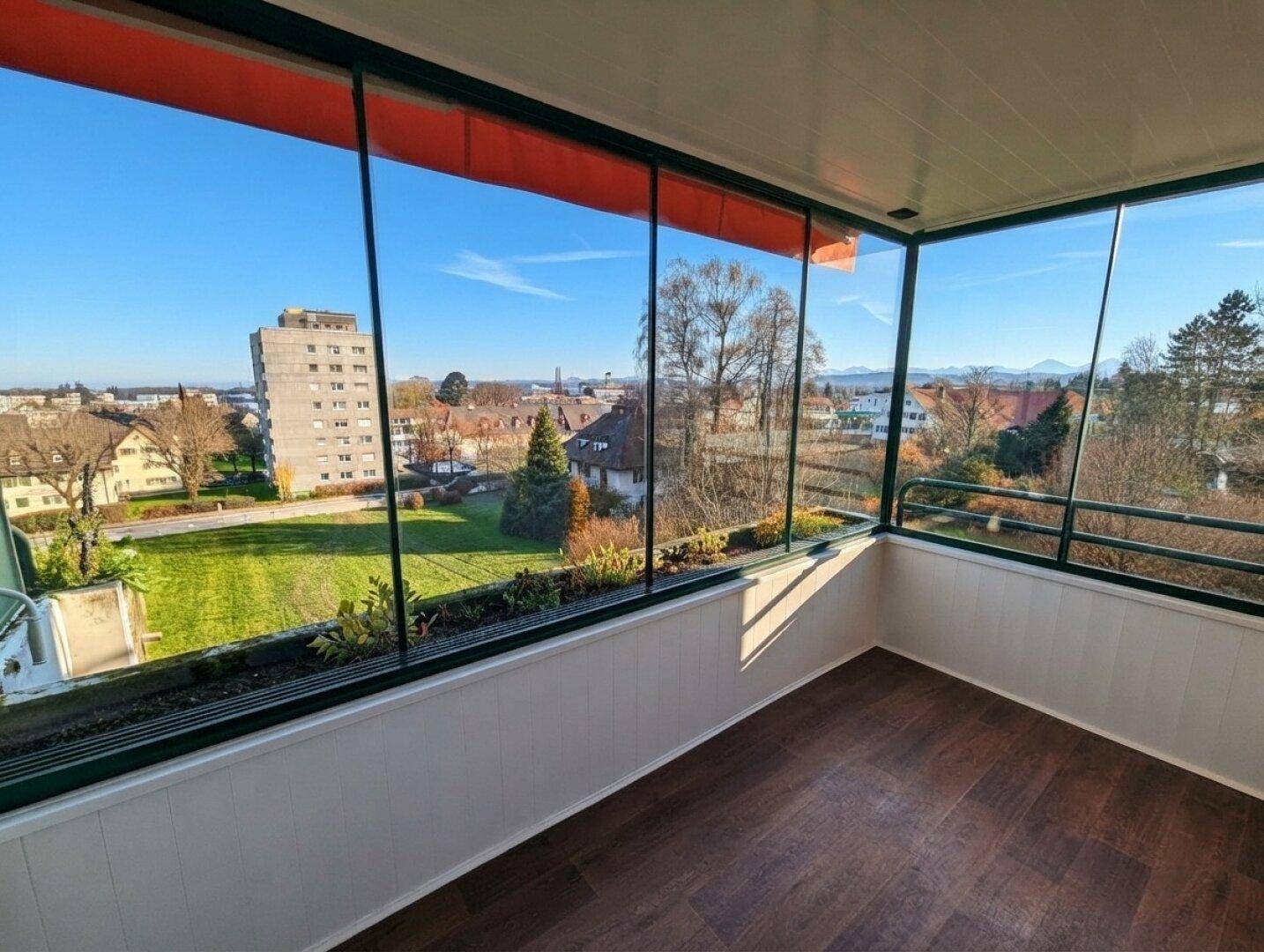 Verglaster Wintergarten mit Panoramablick über die Stadt und den See.