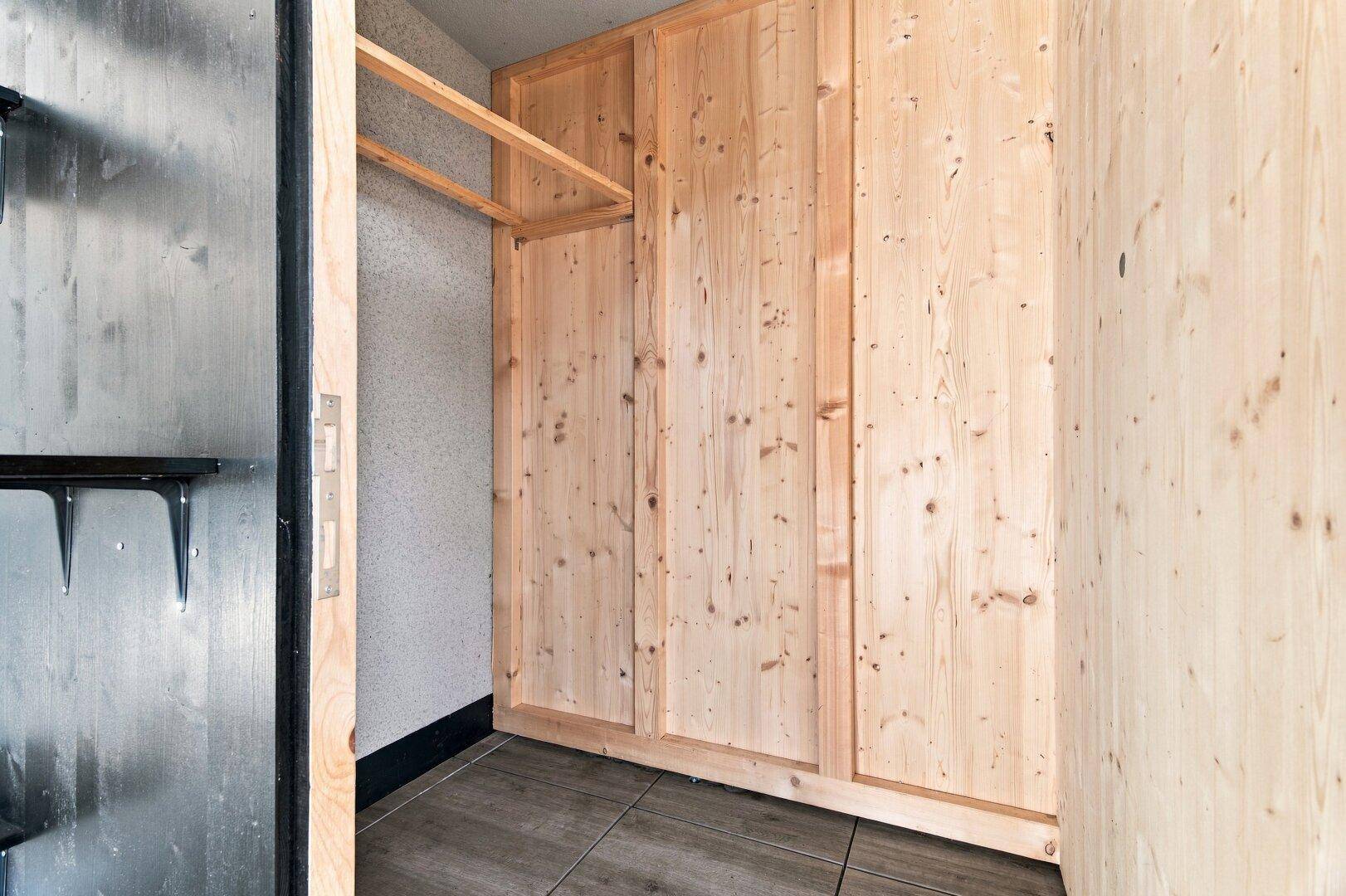 Praktischer Abstellraum mit Holzverkleidung und einfacher Regalkonstruktion.