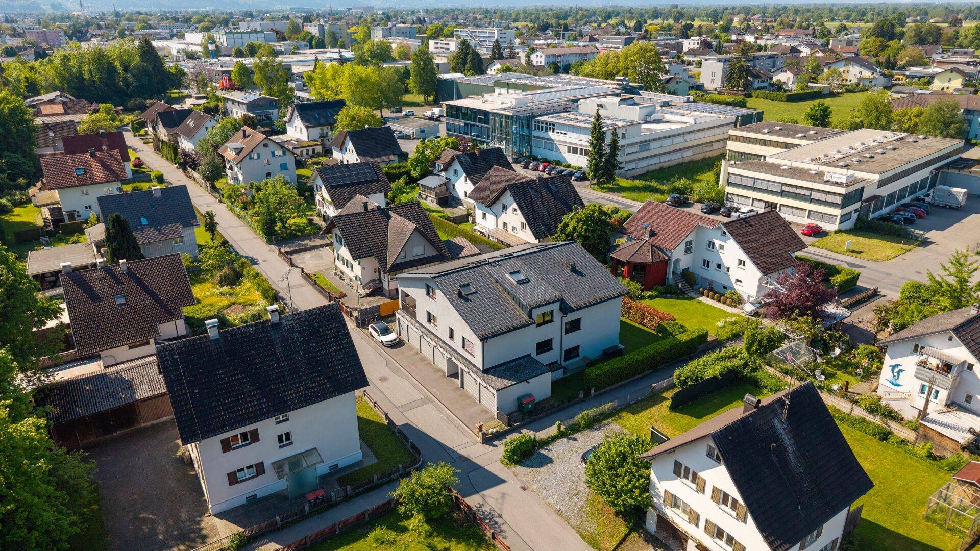 Luftaufnahme einer Wohnsiedlung mit Einfamilienhäusern und viel Grün.