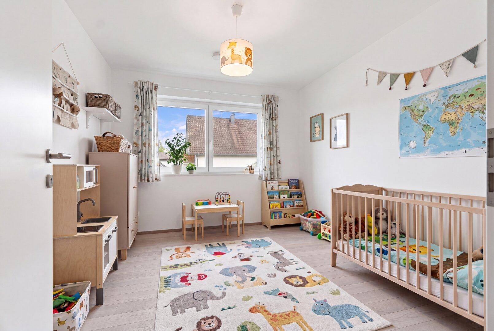 Freundliches Kinderzimmer mit Holzboden, Spielbereich und Blick ins Grüne.