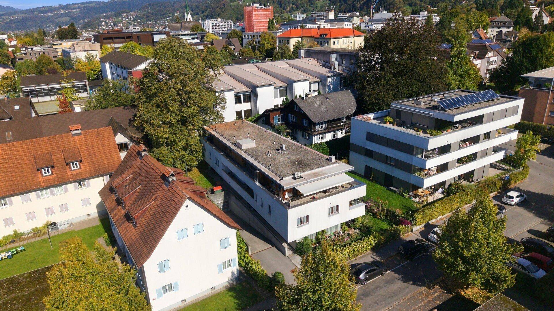Luftaufnahme einer Wohnsiedlung mit verschiedenen Gebäuden und viel Grün.