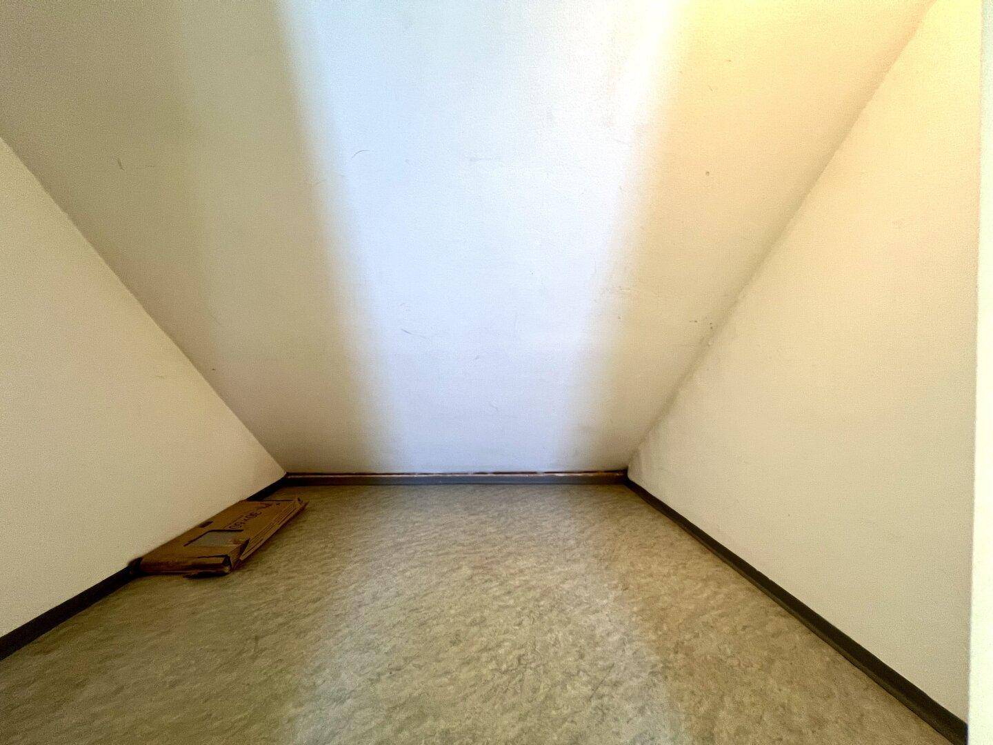 Praktischer Stauraum unter der Dachschräge mit Vinylboden, ideal für Lagerzwecke.