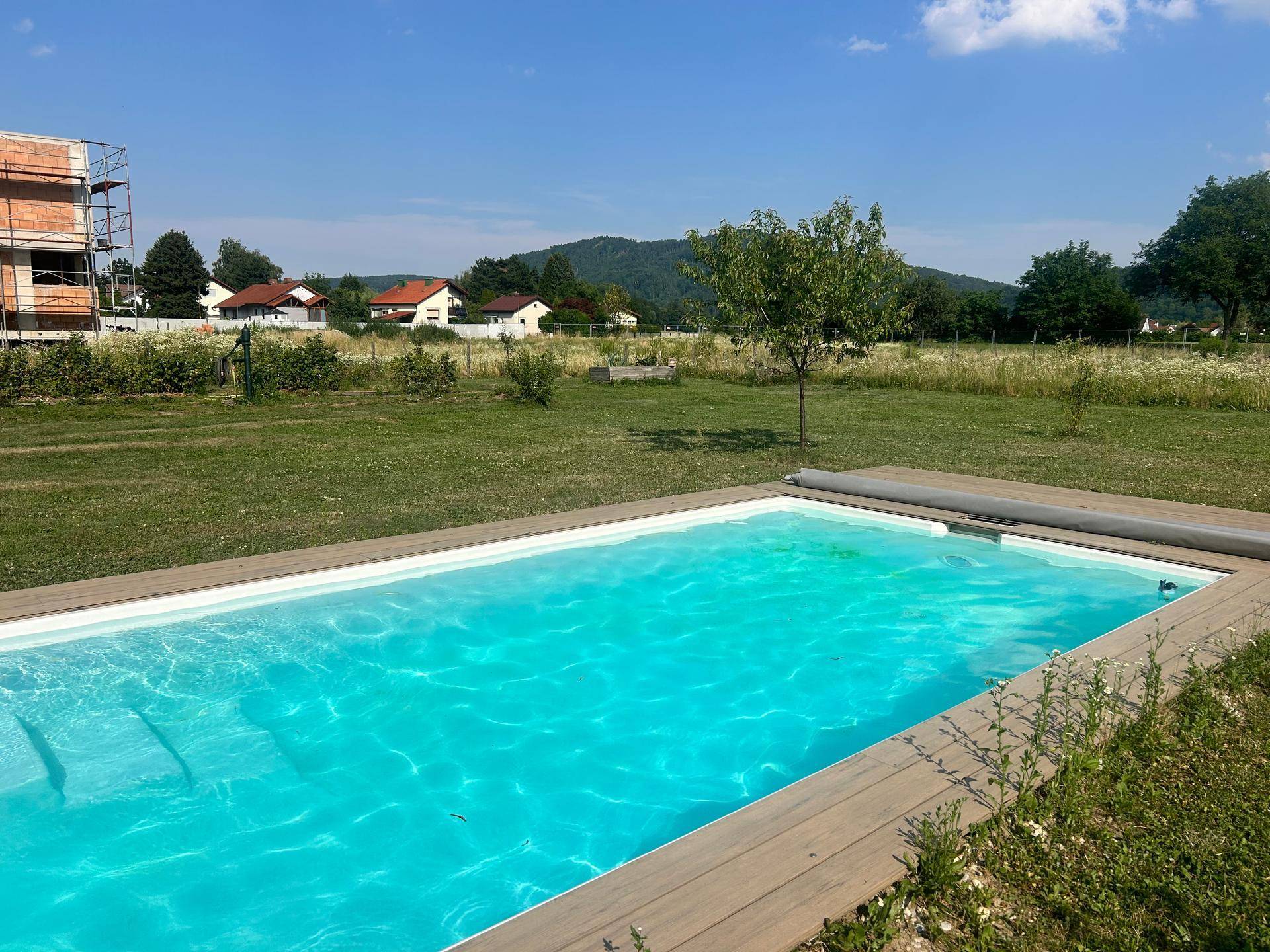Einladender Pool im Garten mit Holzumrandung, ideal für Entspannung unter freiem Himmel.