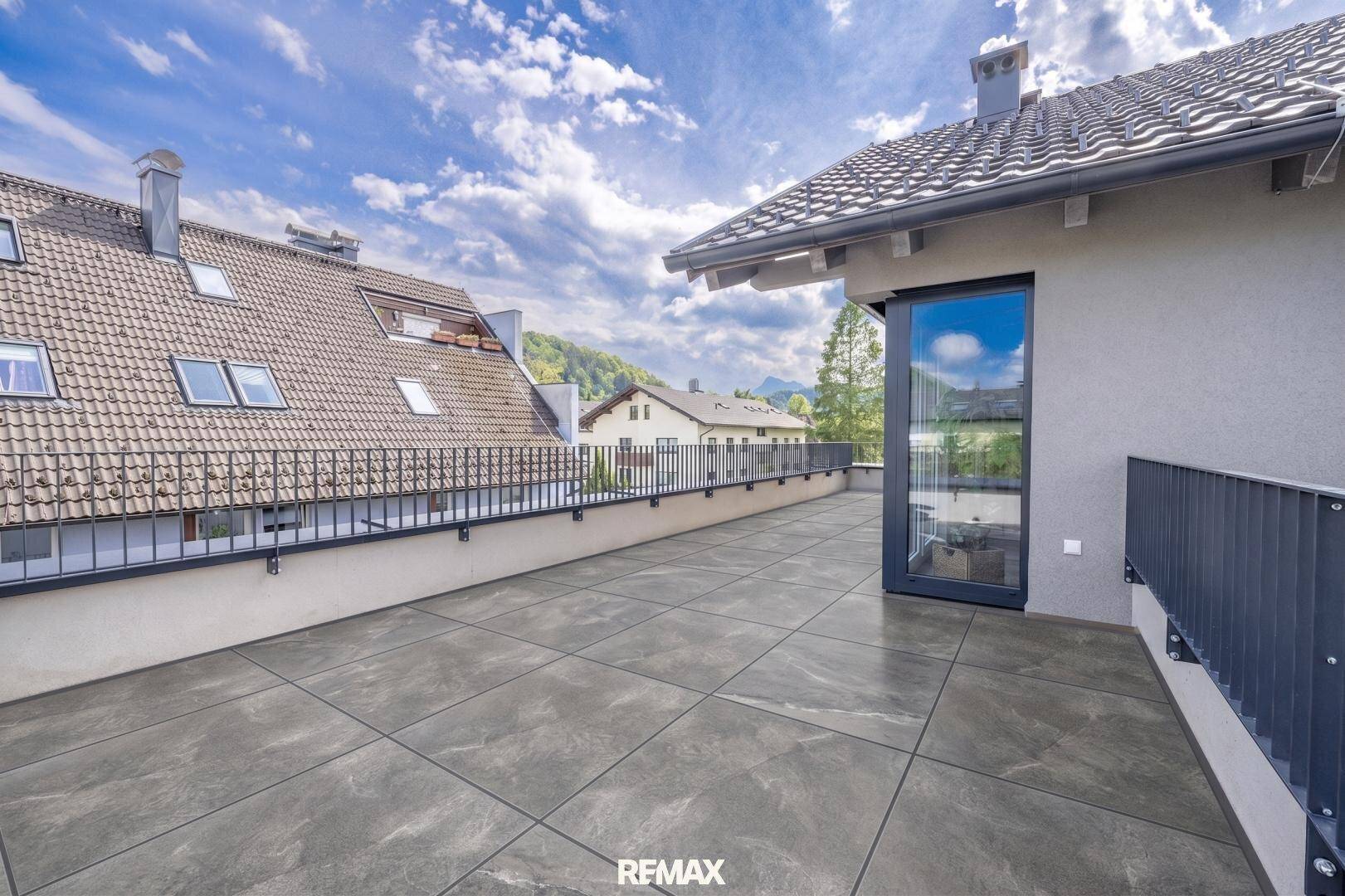 Weitläufige Außenterrasse mit Fliesenboden und Panoramablick auf die Umgebung.